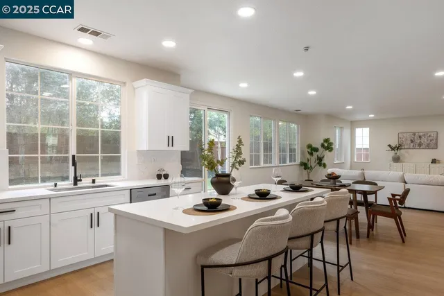 a kitchen with a table chairs and white cabinets