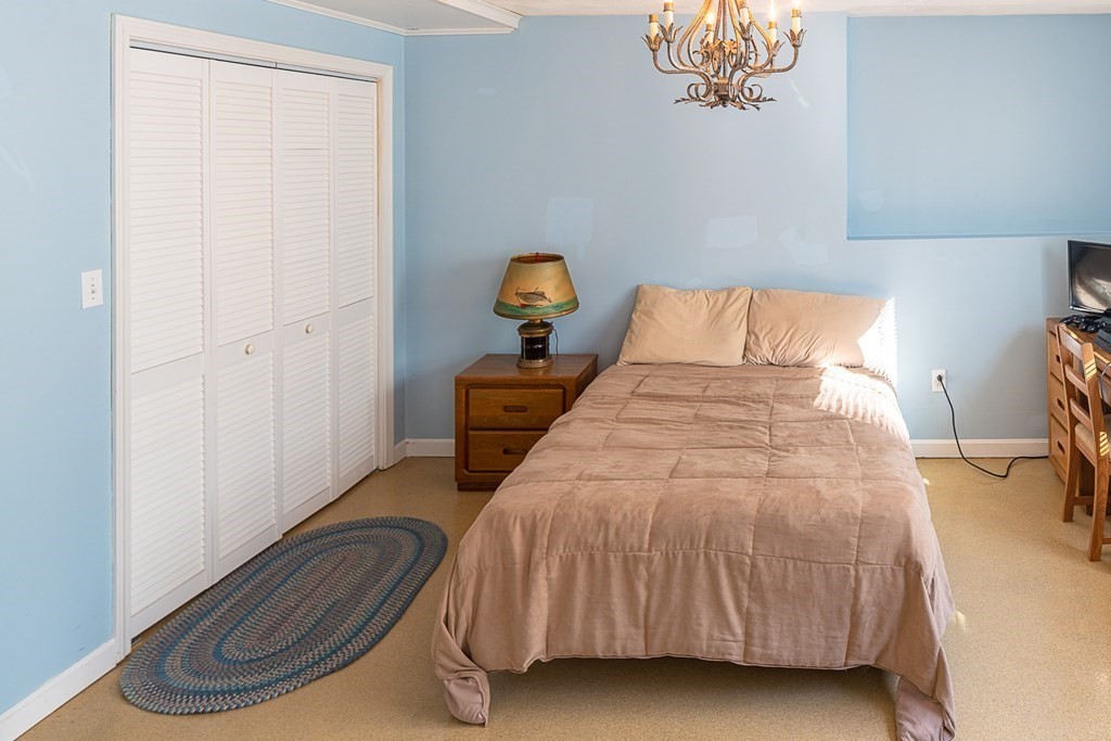 66 Mountwood Road Swampscott, MA 01907 - Photo 20 of 29 a bedroom with a bed and a chandelier