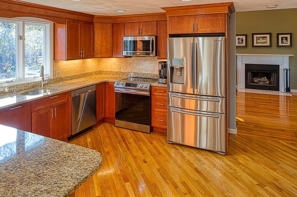 66 Mountwood Road Swampscott, MA 01907 - Photo 5 of 29 a kitchen with stainless steel appliances granite countertop a refrigerator a stove and a wooden floors