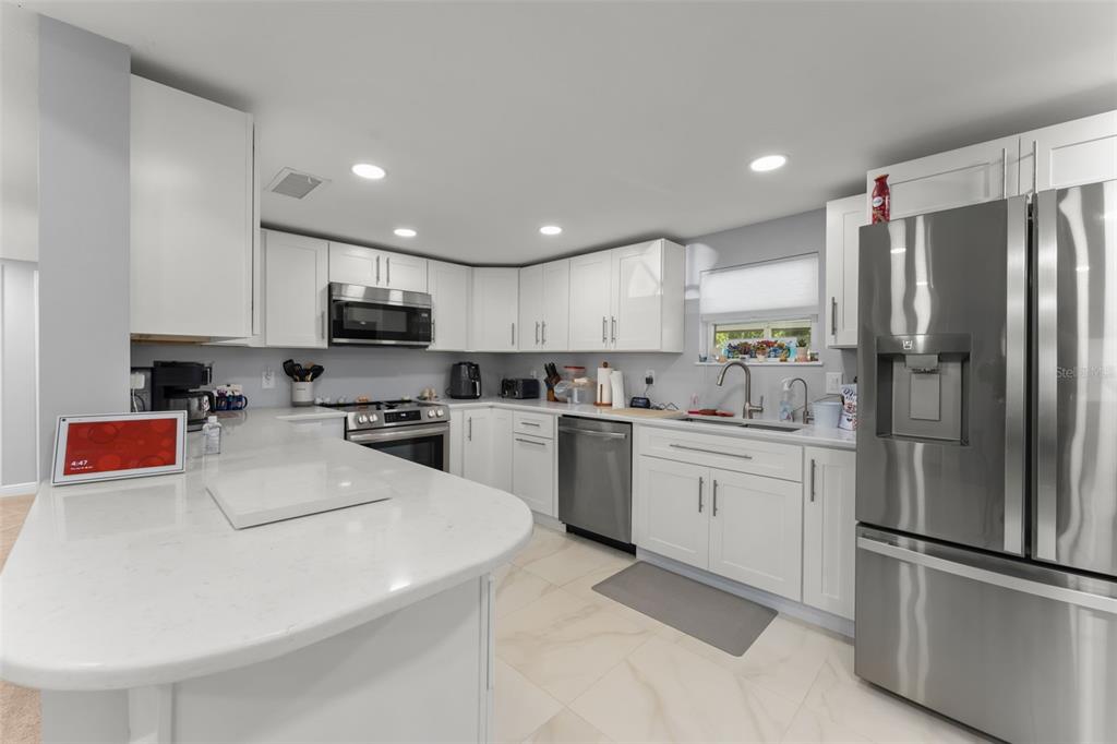 16838 Old Highway 50 East Clermont, FL 34711 - Photo 9 of 51 a kitchen with white cabinets and stainless steel appliances
