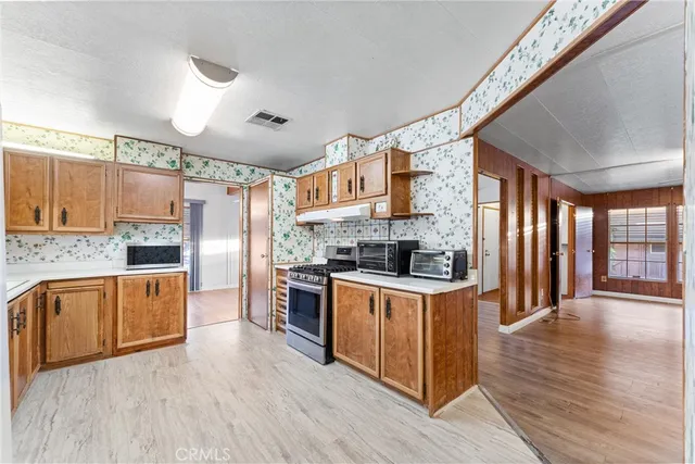 a kitchen with stainless steel appliances kitchen island granite countertop a stove and a sink
