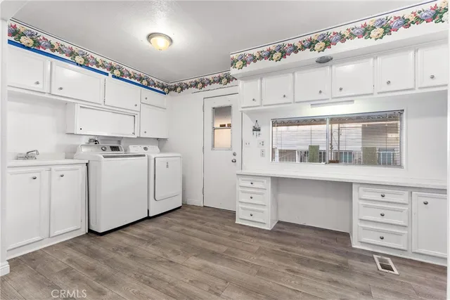 a utility room with cabinets washer and dryer