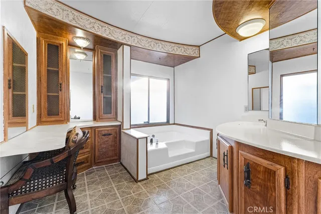 a spacious bathroom with a tub sink and mirror