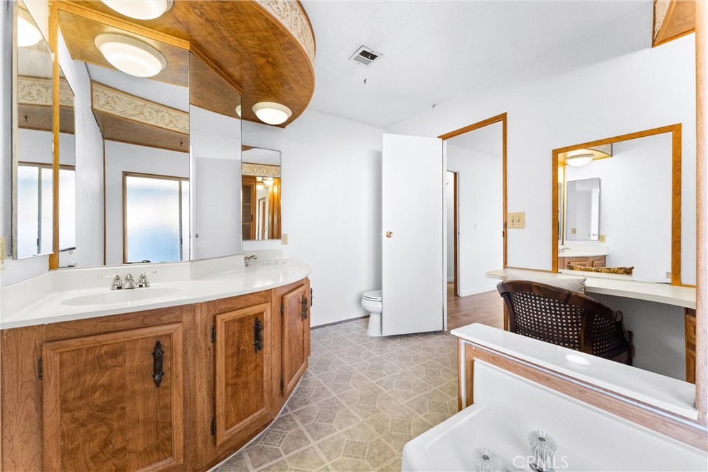 1400 South Sunkist, Unit 80 Anaheim, CA 92806 - Photo 24 of 48 a spacious bathroom with a tub a double vanity sink and a mirror