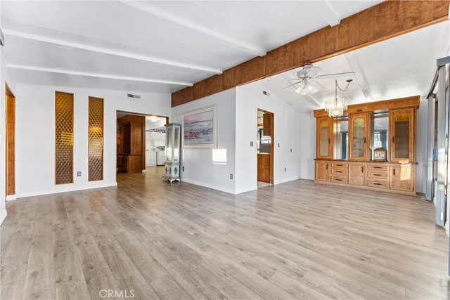 a view of a big room with wooden floor and windows
