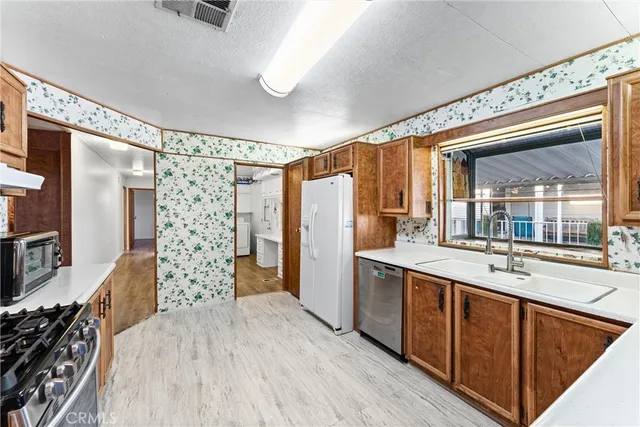 a kitchen with stainless steel appliances granite countertop a refrigerator and a sink