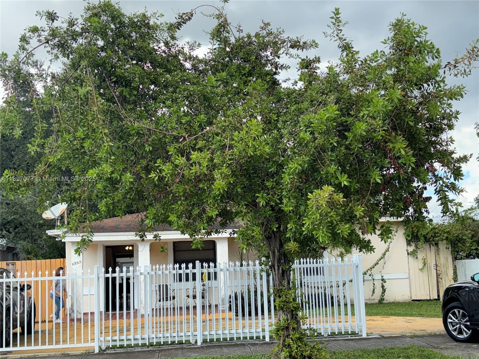 a view of a house with a small yard and wooden fence