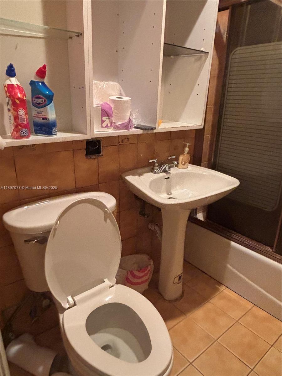 6261 Southwest 6th Street Miami, FL 33144 - Photo 14 of 29 a bathroom with a toilet a sink and mirror