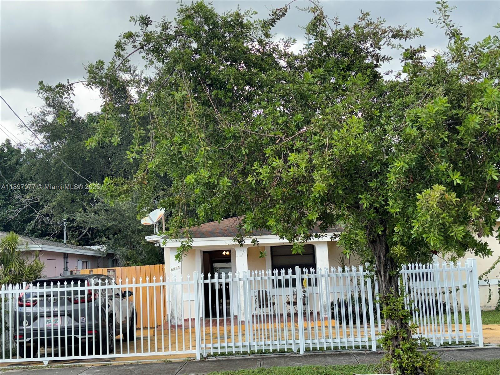 6261 Southwest 6th Street Miami, FL 33144 - Photo 2 of 29 a view of a white house with a small yard and deck