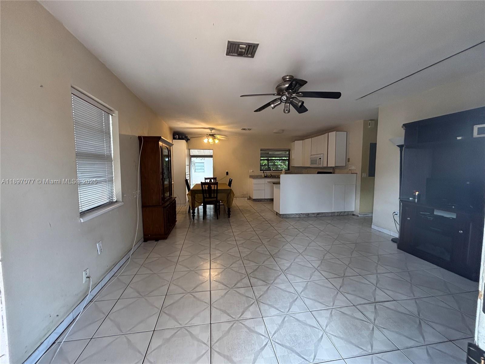 6261 Southwest 6th Street Miami, FL 33144 - Photo 4 of 29 a view of a kitchen with furniture and a ceiling fan