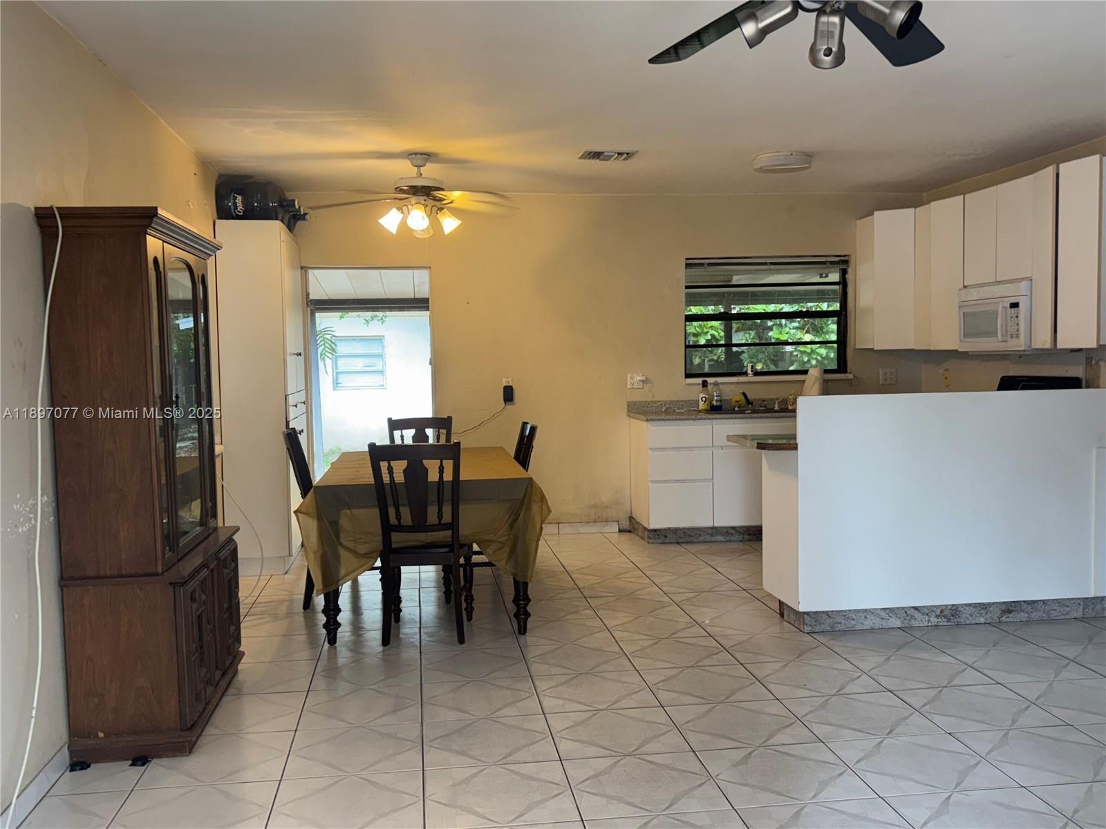 6261 Southwest 6th Street Miami, FL 33144 - Photo 5 of 29 a kitchen with stainless steel appliances a refrigerator and a dining table