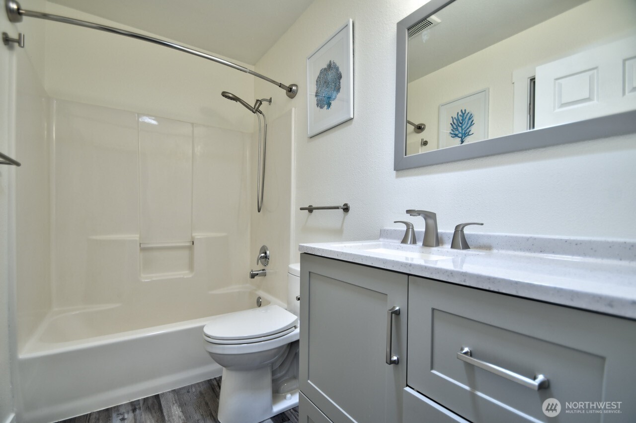 8603 194th Avenue Southwest Rochester, WA 98579 - Photo 24 of 32 a bathroom with a toilet a sink a mirror and a bathtub