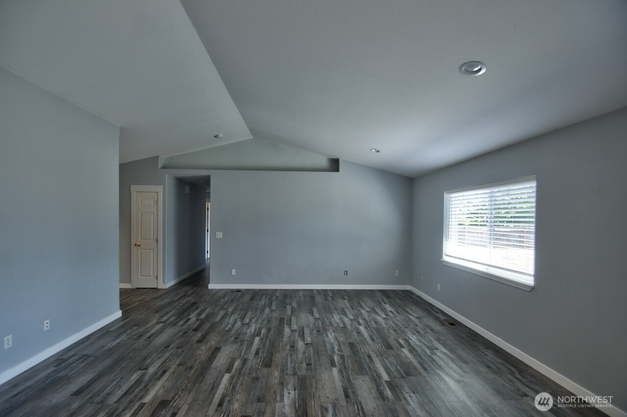 8603 194th Avenue Southwest Rochester, WA 98579 - Photo 5 of 32 an empty room with wooden floor and windows