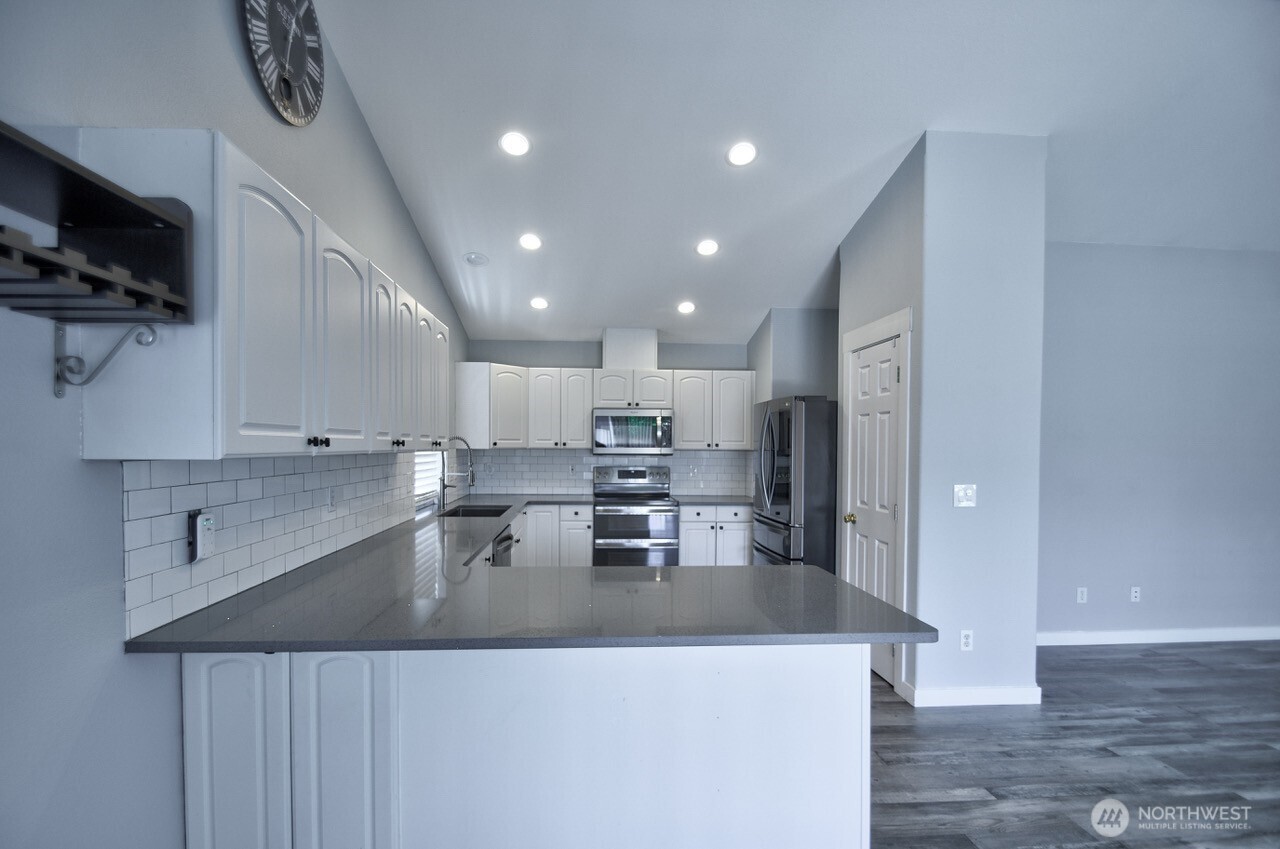 8603 194th Avenue Southwest Rochester, WA 98579 - Photo 10 of 32 a kitchen with stainless steel appliances granite countertop a sink a stove and a refrigerator