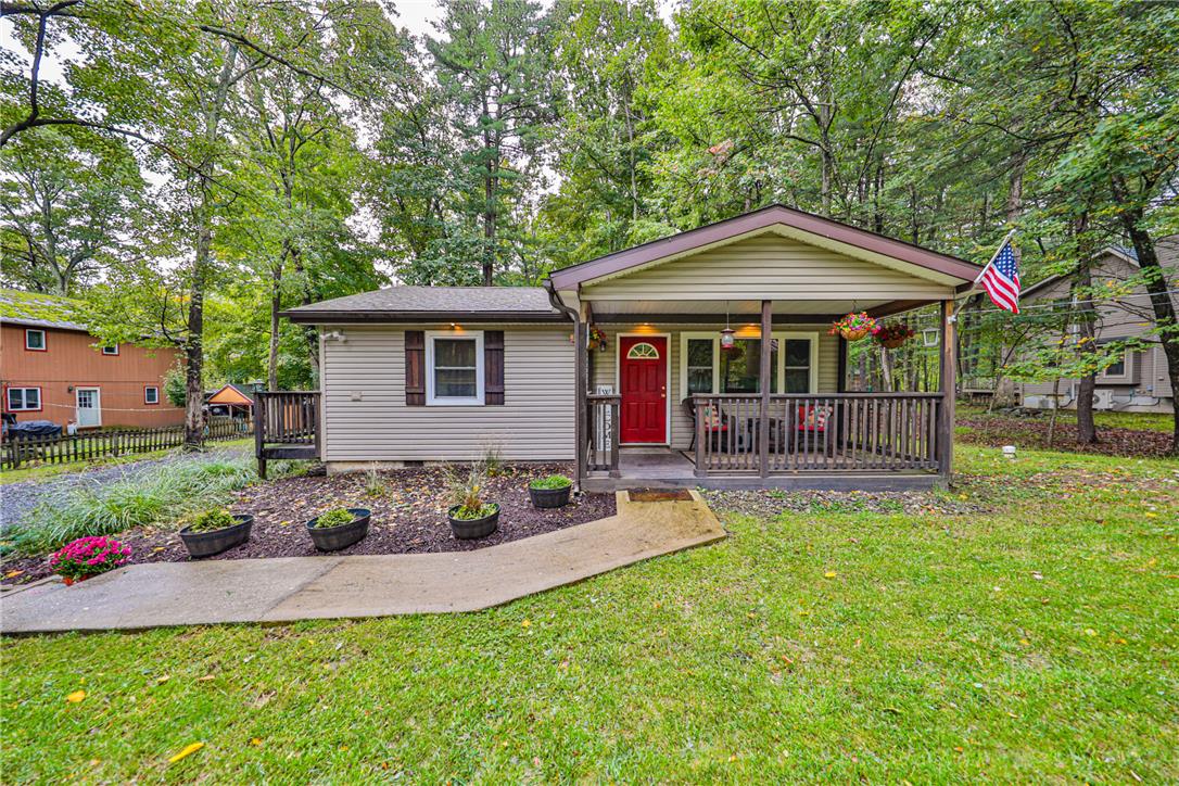 24 Turkey Ridge Road East Stroudsburg, PA 18302 - Photo 2 of 34 Mature trees frame a welcoming front porch and concrete walkway leading to the entry.