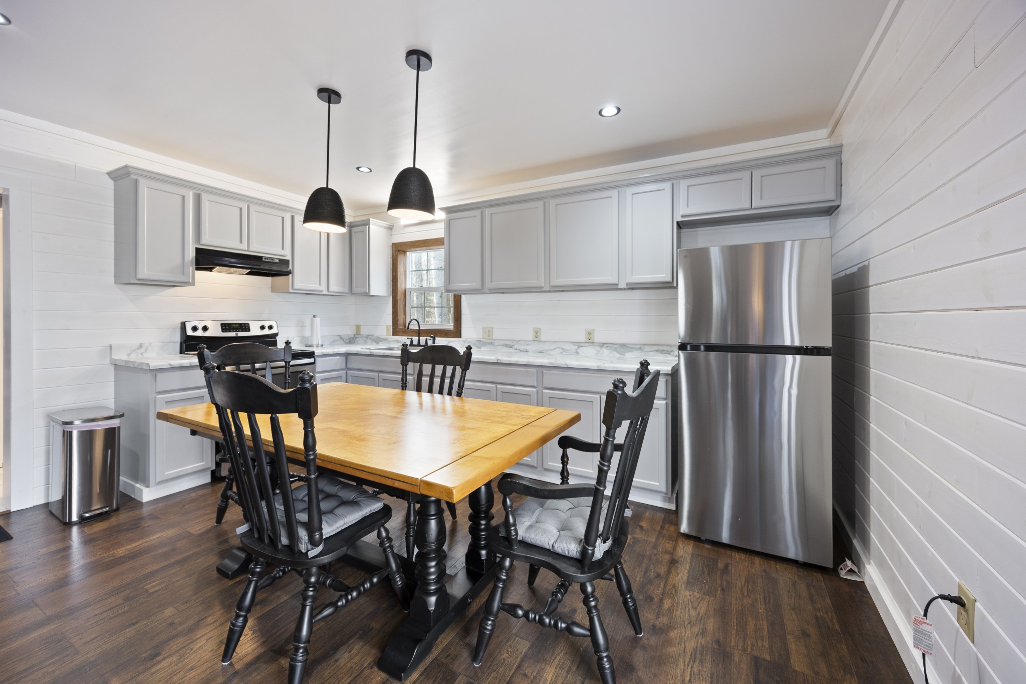 1085 Henegar Road Morrison, TN 37357 - Photo 3 of 17 a kitchen with stainless steel appliances a dining table chairs refrigerator and cabinets