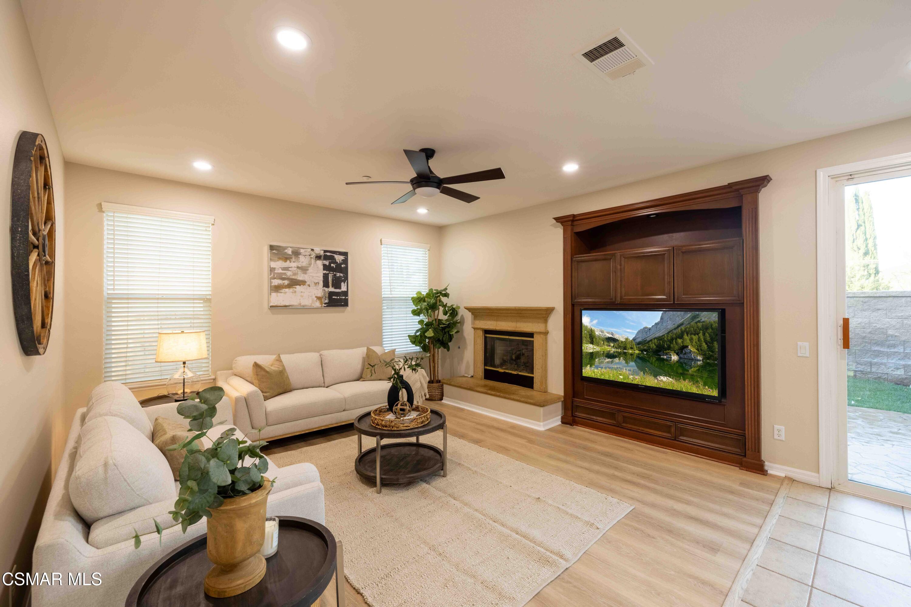 5353 Willow Oak Street Simi Valley, CA 93063 - Photo 26 of 52 a living room with furniture a fireplace and a floor to ceiling window