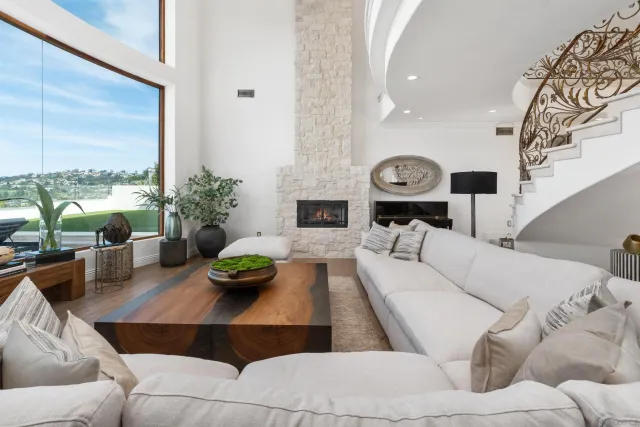 a living room with furniture a fireplace and a chandelier
