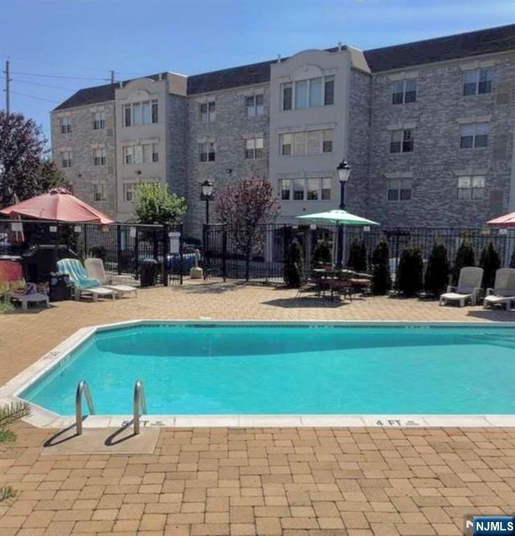 132 Union Avenue, Unit 405A East Rutherford, NJ 07073 - Photo 11 of 11 a swimming pool with outdoor seating and yard