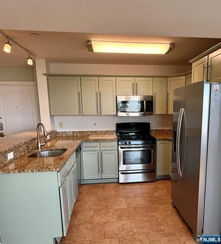 a kitchen with kitchen island granite countertop a sink stainless steel appliances and cabinets