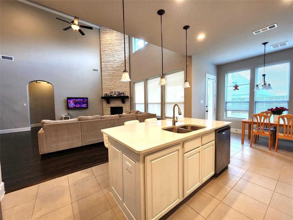 7163 Split Rein Road Frisco, TX 75036 - Photo 11 of 40 a kitchen with stainless steel appliances kitchen island granite countertop a sink a counter top space a dining table a chandelier and a view of living room