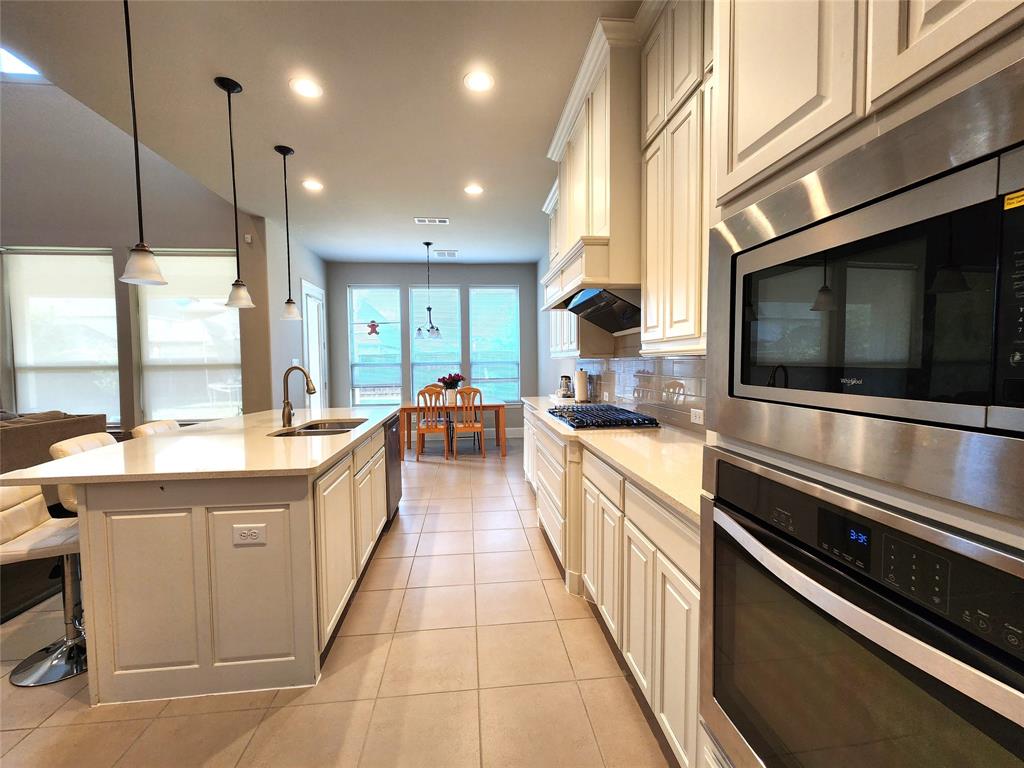 7163 Split Rein Road Frisco, TX 75036 - Photo 12 of 40 a large kitchen with stainless steel appliances and a sink