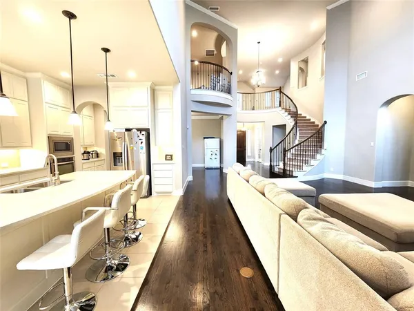 a living room with furniture a large window and wooden floor