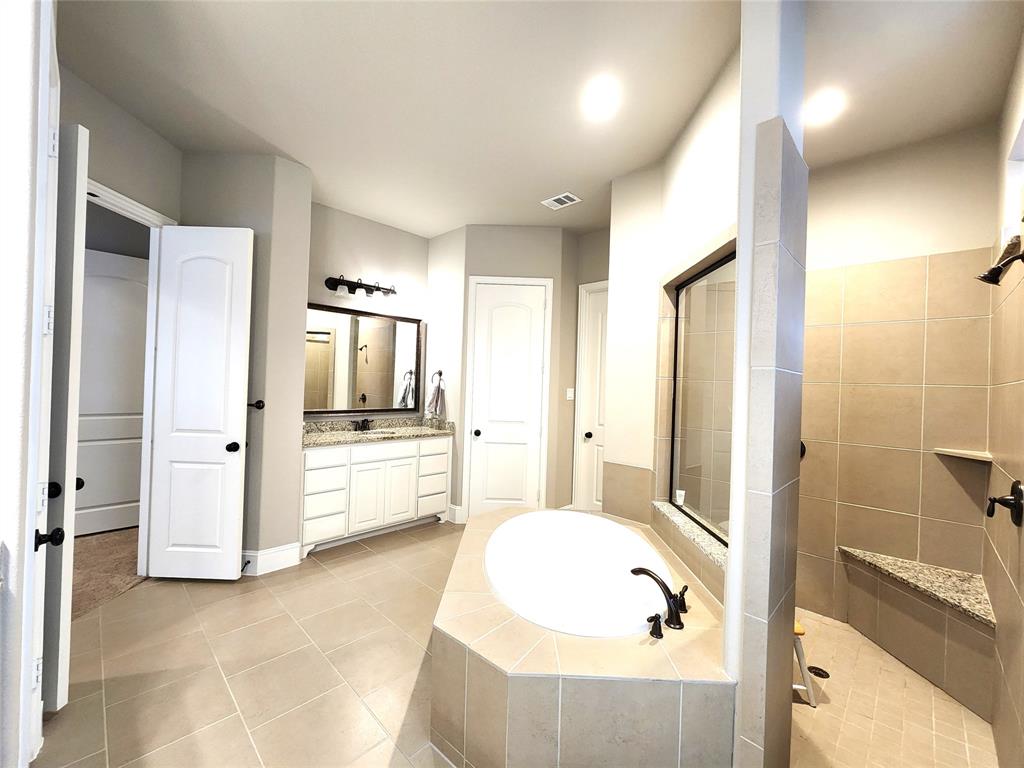 7163 Split Rein Road Frisco, TX 75036 - Photo 22 of 40 a bathroom with a tub shower and mirror