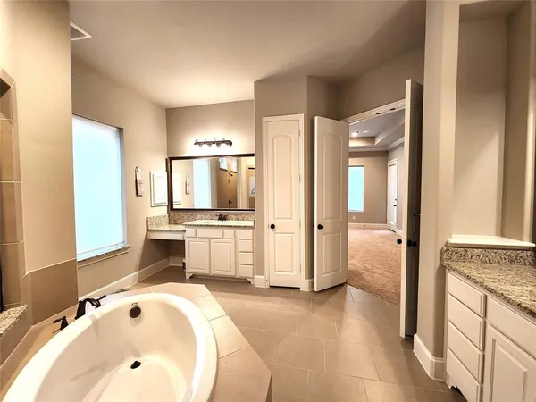 a bathroom with a tub sink and mirror