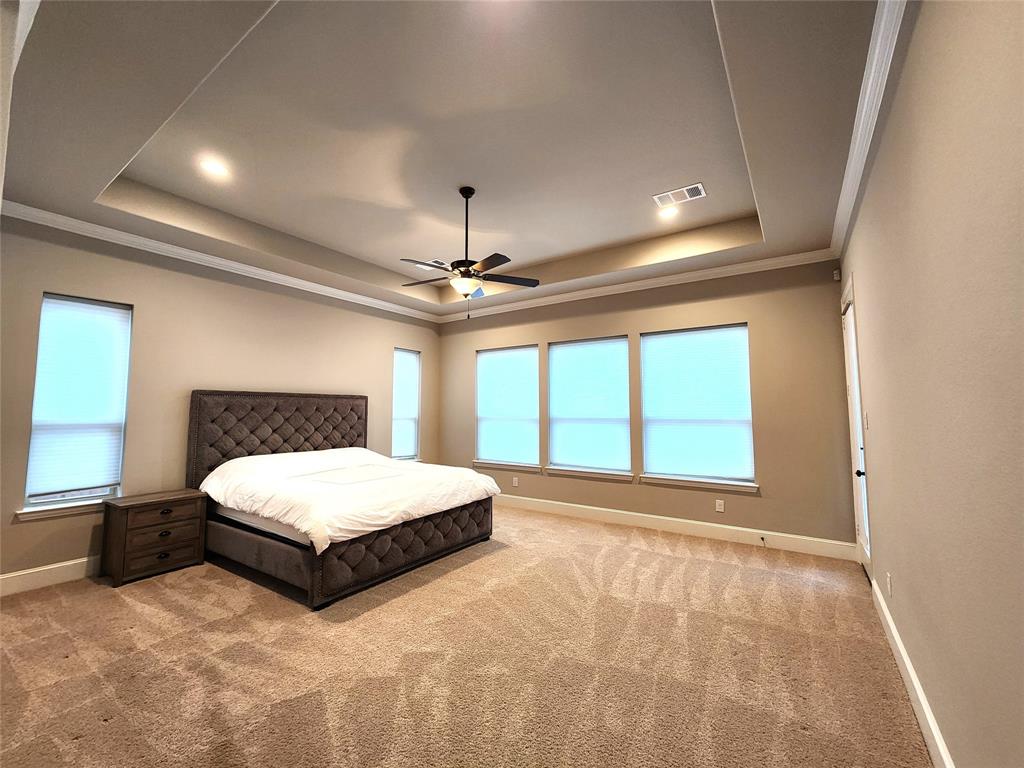 7163 Split Rein Road Frisco, TX 75036 - Photo 25 of 40 a spacious bedroom with a large bed and a large window