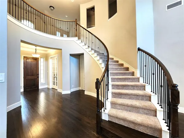 a view of staircase with wooden floor and a chandelier