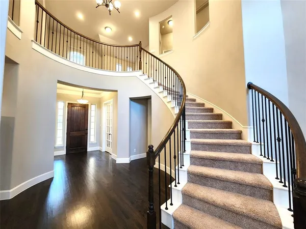 a view of staircase with lots of frames on wall and wooden floor