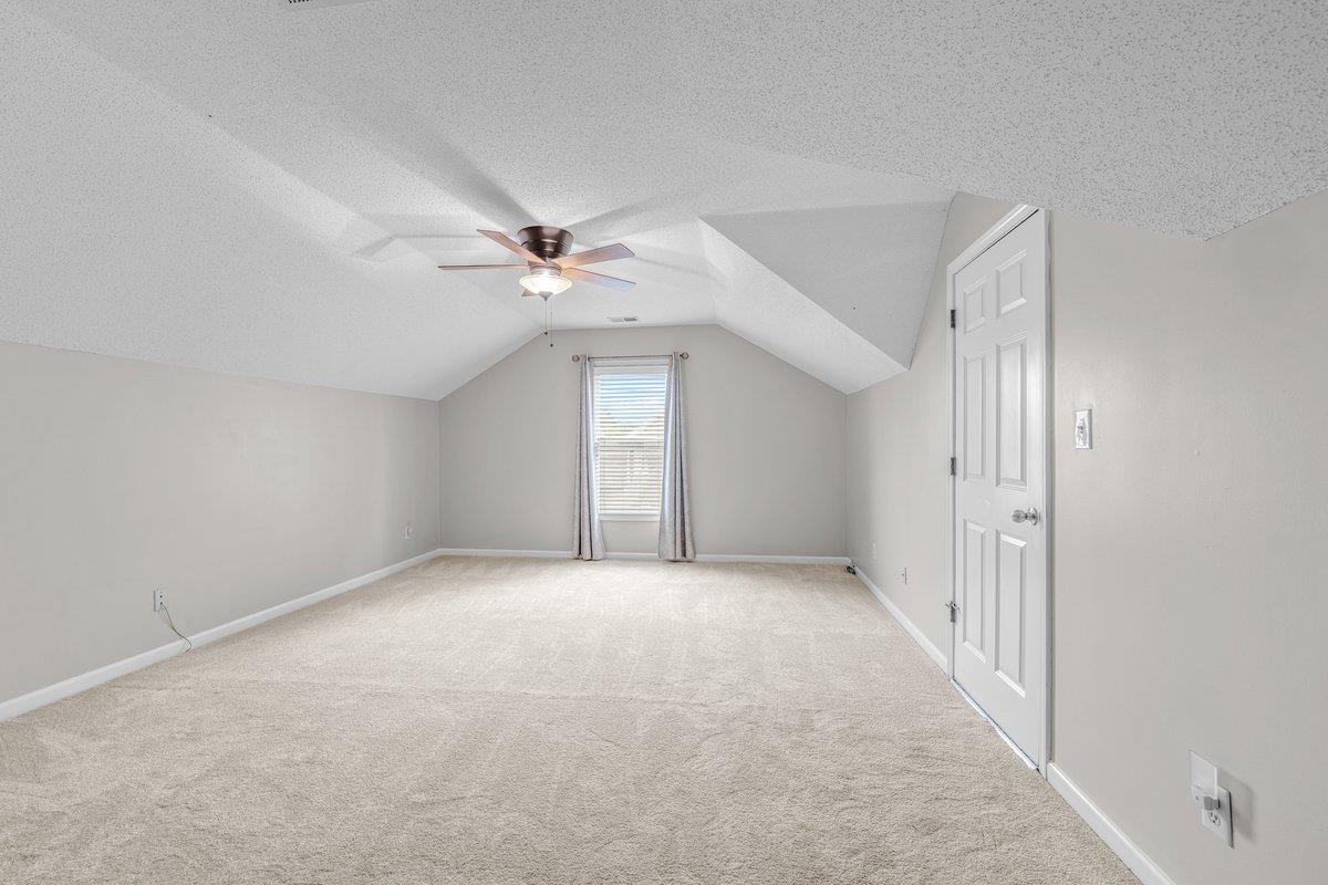 4840 Rainy Pass Road Collierville, TN 38017 - Photo 20 of 30 Carpeted room featuring a sloped ceiling, ceiling fan with integrated lighting, and a single window with curtains