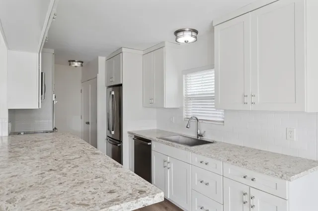 a kitchen with granite countertop a sink and a stove