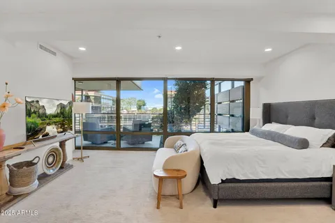 a bedroom with a bed and large window