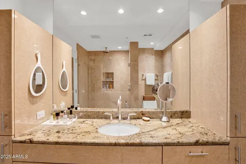a bathroom with a granite countertop sink and a mirror