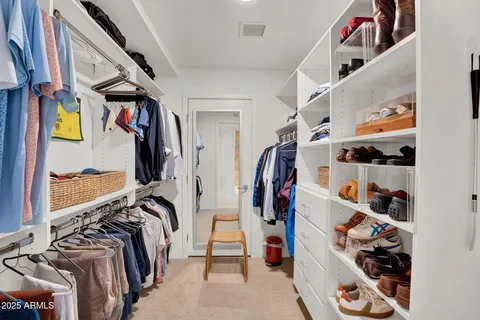 a view of walk in closet with clothes and shoes
