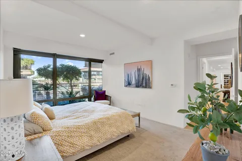 a bedroom with a large bed and a potted plant