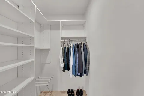 a view of walk in closet with clothes and shoes