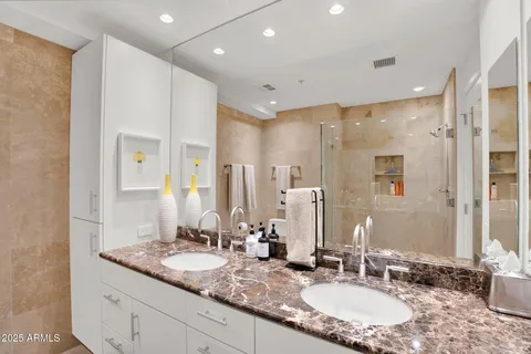 a bathroom with double vanity sinks and a mirror
