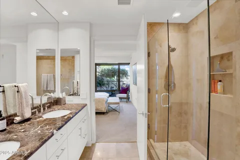 a large bathroom with a granite countertop double vanity sink a mirror and a bathtub