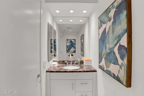 a bathroom with a granite countertop sink a mirror and a shower