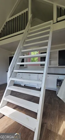 a view of a hallway with wooden floor and stairs