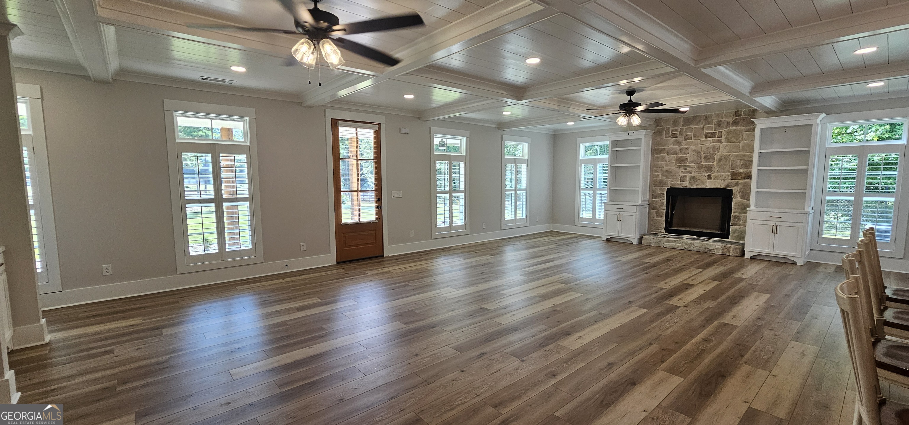 654 Liberty Hill Road Milner, GA 30257 - Photo 90 of 180 an empty room with wooden floor fireplace and windows