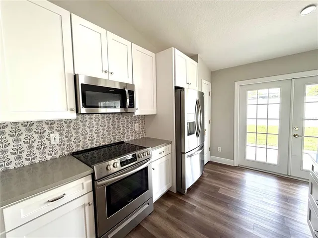 a kitchen with stainless steel appliances a stove microwave and a refrigerator
