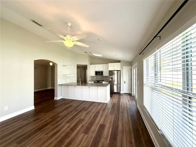 a kitchen with stainless steel appliances granite countertop a stove top oven a sink and cabinets