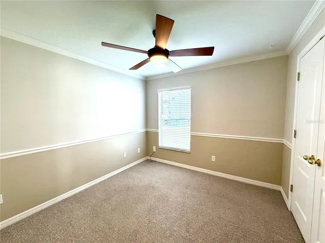 an empty room with a window and a ceiling fan
