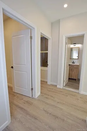 a view of a hallway with wooden floor and closet