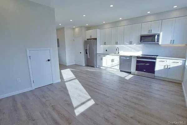 a large kitchen with stainless steel appliances granite countertop a large counter top and a stove top oven