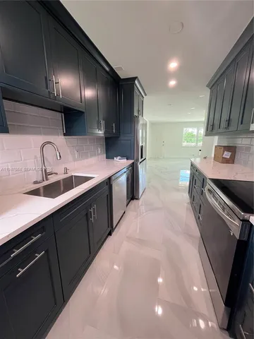 a kitchen with stainless steel appliances a sink stove and cabinets
